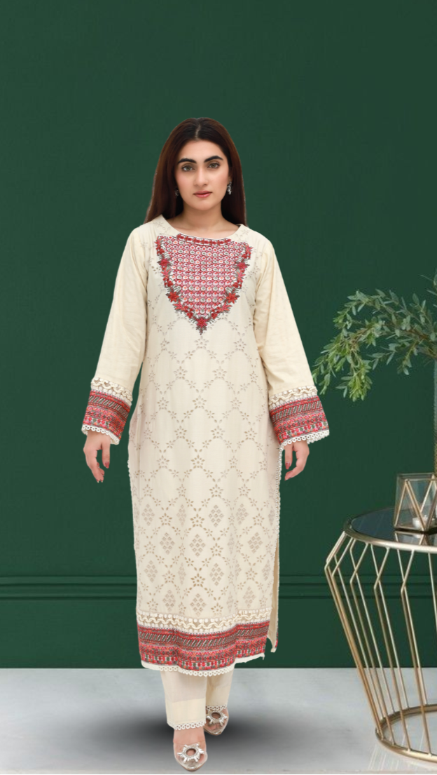 Daiselle Woman wearing a cream embroidered dress with red patterns in a minimalistic room.