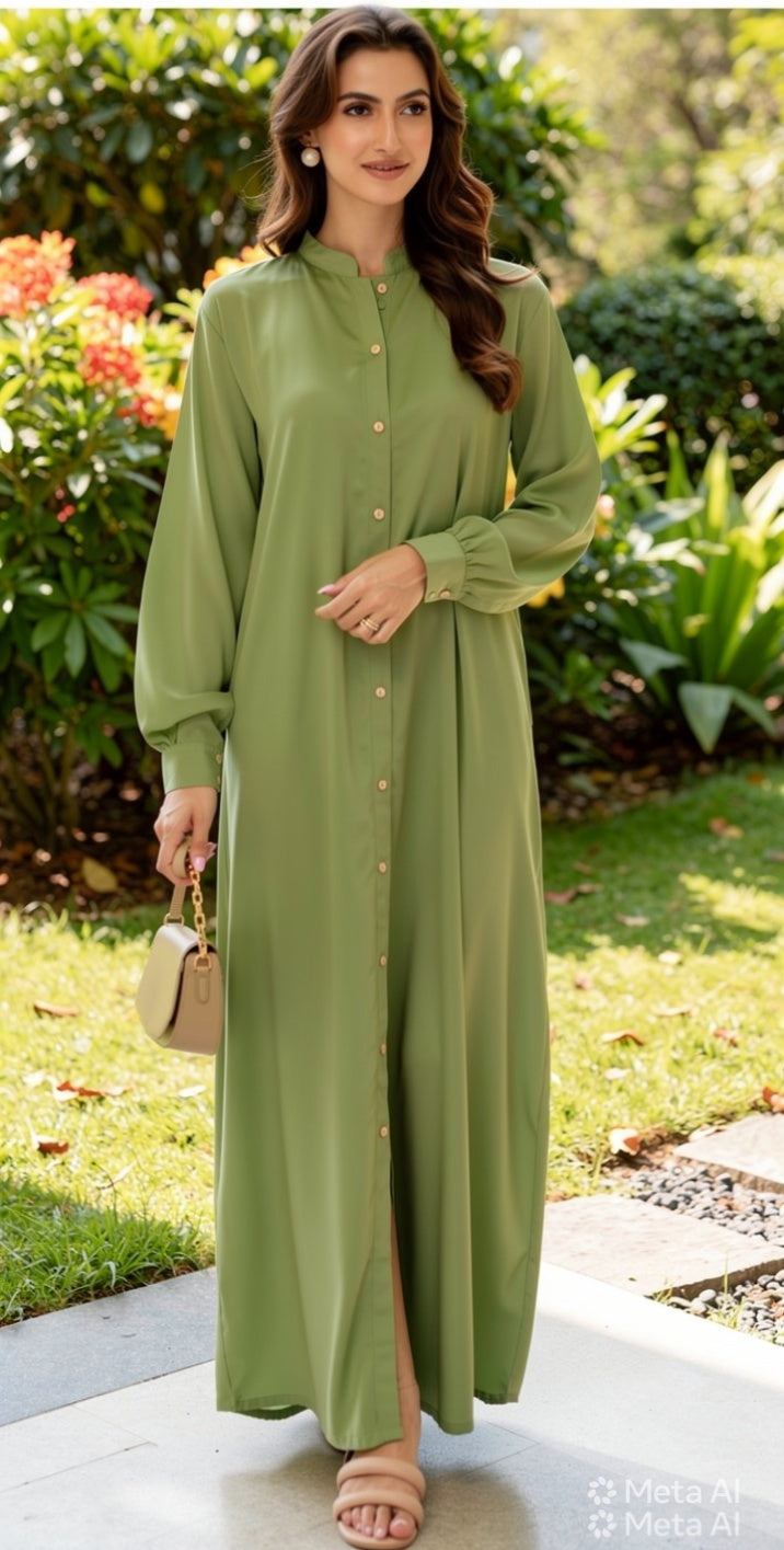 Woman wearing a green dress standing outdoors with greenery in the background